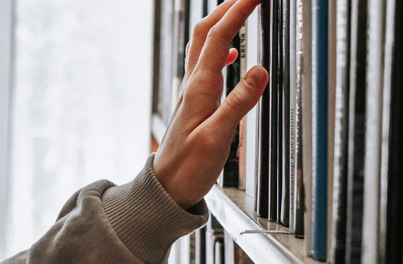 手在書架上滑動尋找書籍